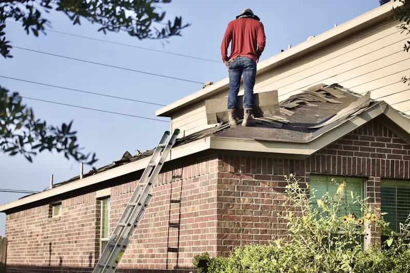 Professional roofer working on a residential roof in Wister Woods